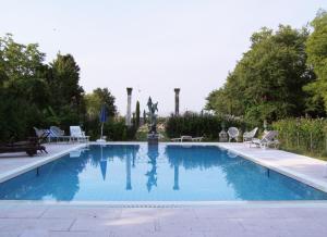 a swimming pool with chairs and a fountain at Villa Navagero Erizzo - Ca' Rocchetto 2 in Rovarè