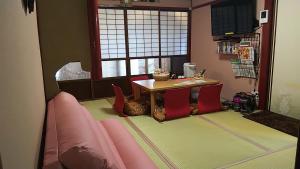 a dining room with a table and red chairs at Thank you so muchya Miyaco in Kyoto