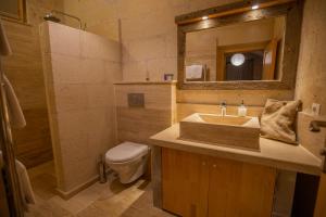 a bathroom with a sink and a toilet and a mirror at Maze Of Cappadocia Hotel in Uçhisar