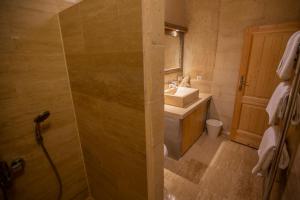 a bathroom with a sink and a shower with a mirror at Maze Of Cappadocia Hotel in Uchisar