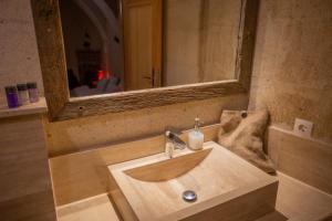 a bathroom with a wooden sink with a mirror at Maze Of Cappadocia Hotel in Uchisar