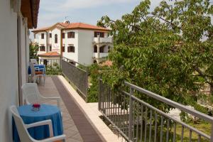 a balcony with a table and chairs and a building at Apartment La roza in Funtana