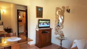 uma sala de estar com uma televisão e um espelho na parede em Apartment La roza em Funtana