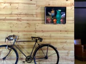 a bike parked against a wooden wall with a painting at Hostal Can Maret in Vilademuls