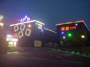 尤九Apple Drive-in Hotel的一座晚上有 ⁇ 虹灯标志的建筑