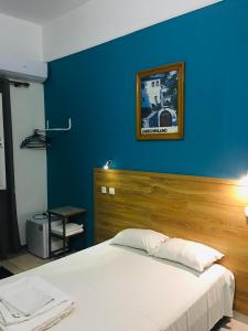 a bedroom with a blue wall and a white bed at Hotel Kastoria in Thessaloniki