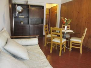 ein Wohnzimmer mit einem Bett, einem Tisch und Stühlen in der Unterkunft Cerca de Todo in Miramar