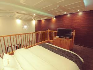 a bedroom with a bed and a flat screen tv at Apple Drive-in Hotel in Yeoju