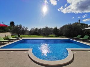 a swimming pool with green chairs and a blue sky at House ANA - Loborika, Pula, 4 bedrooms in Loborika