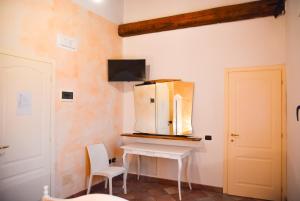 a kitchen with a white table and a refrigerator on a wall at Agriturismo La Rebosola in Ca Zennare