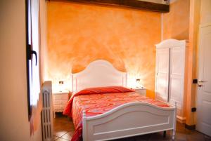 a bedroom with a bed with an orange wall at Agriturismo La Rebosola in Ca Zennare