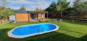 a tiny house with a swimming pool in the yard at Prażmowo 49 in Prażmowo
