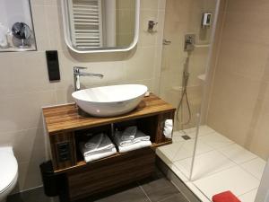 ein Bad mit einem Waschbecken und einer Dusche in der Unterkunft Hotel An der Philharmonie in Köln