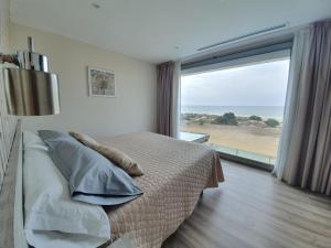a bedroom with a bed and a large window at Hotel Boutique Aroma de Mar in Chiclana de la Frontera