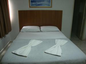 białe łóżko z białymi ręcznikami w obiekcie D'arc Hotel w mieście Goiânia
