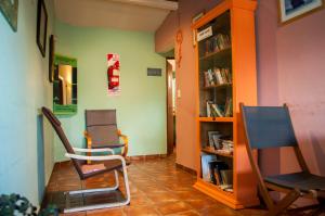 two chairs and a book shelf in a room at Patagonia Jazz Hostel in San Carlos de Bariloche