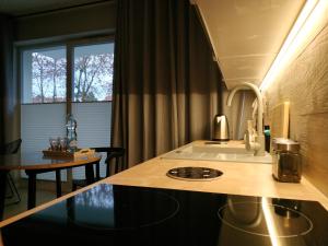 a kitchen with a counter with a sink and a window at Apartament Limanowskiego 20/6 in Bartoszyce