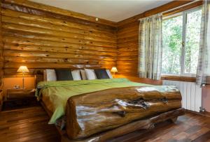 - une chambre en rondins avec un lit dans une cabane en rondins dans l'établissement B&B Casapuelo, à Lago Puelo
