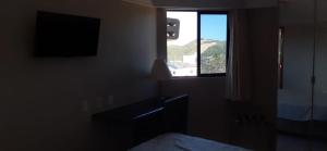 1 dormitorio con ventana y vistas a la montaña en LINDO APARTAMENTO COM VISTA - PRAIA DE PONTANEGRA, en Natal