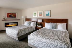a hotel room with two beds and a fireplace at The Crimson Jasper in Jasper