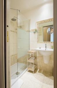 a bathroom with a glass shower and a sink at Capitolium Rooms in Rome