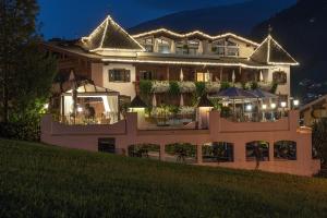 een groot gebouw met 's nachts verlichting bij Hotel Alpenblick Zillertal in Hippach +79 foto's