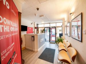 a waiting room with a row of chairs and a counter at OYO Devine Beach Hotel, Westcliff Southend-On-Sea in Southend-on-Sea