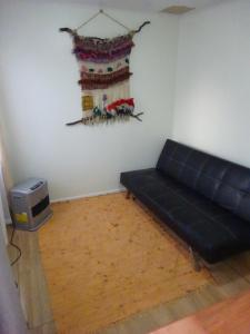 sala de estar con sofá y TV en Cabañas Parque Villarrica, en Villarrica