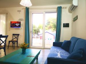 a living room with a blue couch and a table at TorreBlu Residence in Torre Lapillo