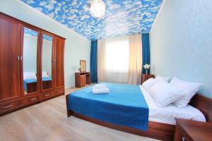 een slaapkamer met een bed met een blauw plafond bij Razmestim в ЖК Айгерим in Alma-Ata