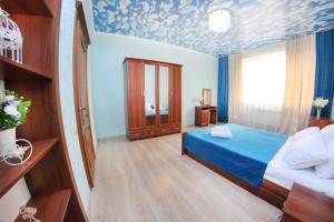 een slaapkamer met een bed en een blauw plafond bij Razmestim в ЖК Айгерим in Alma-Ata