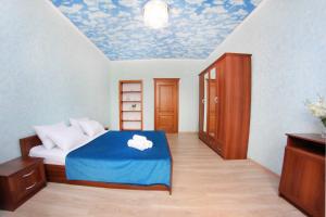 een slaapkamer met een bed met een blauwe deken bij Razmestim в ЖК Айгерим in Alma-Ata