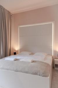 een slaapkamer met een wit bed en 2 handdoeken bij B&B Concept in Zagreb