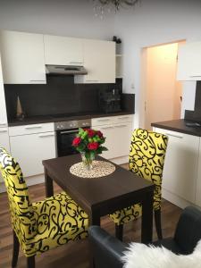 una cocina con una mesa con un jarrón de flores. en Apartment Elfi, en Leibnitz