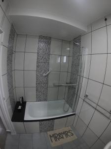 een kleine badkamer met een bad en een douche bij Aijpel Loft in Ushuaia