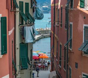 a view of a canal from between buildings with umbrellas at El Nin Apartment with Terrace in Vernazza