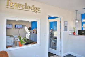 a shop with a large window with a knowledge sign on the wall at Travelodge by Wyndham Crescent City in Crescent City