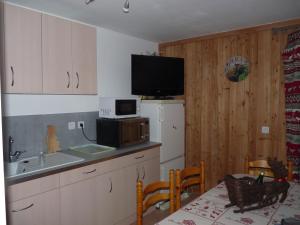 una cucina con lavandino e una TV a parete di la grange a Crévoux