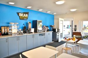 a bar with white cabinets and a blue wall at Travelodge by Wyndham Crescent City in Crescent City +26 photos