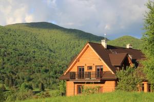 a wooden house with a balcony in the mountains at Bojkowa Chata in Smerek