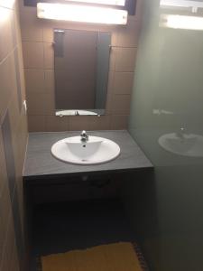 a bathroom with a sink and a mirror at Auberge de Poé in Bourail