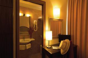baño con lavabo, espejo y lámpara en Hotel Novecento, en Roma