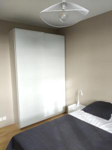 - une chambre avec un lit et un grand placard blanc dans l'établissement Appartement au centre de Saint Briac, à Saint-Briac-sur-Mer