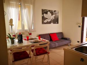 een keuken en een woonkamer met een tafel en een bank bij Bilocale via Montefiore Conca in Riccione