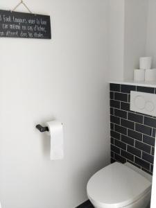 a bathroom with a toilet and a sign on the wall at Appartement au centre de Saint Briac in Saint-Briac-sur-Mer