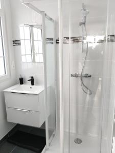 サン・ブリアック・シュル・メールにあるAppartement au centre de Saint Briacの白いバスルーム(シャワー、シンク付)