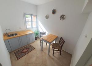 a kitchen with a table and chairs and a sink at Traditional Apartments Alexandra in Meyisti +9 photos