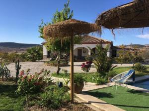 アルコス・デ・ラ・フロンテーラにあるVilla entre mer et montagneの椅子と藁傘付きの庭園