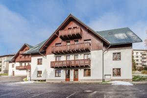 een groot houten gebouw met balkons in een straat bij Apartmán Krakonoš in Rokytnice nad Jizerou