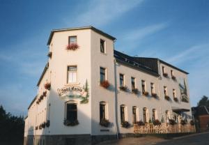 un gran edificio blanco con un cartel. en Hotel Carola, en Schönheide